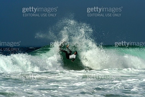 Lisbon, Portugal - October 2009: Surfer surprised by a closing wave falls from his surfboard. He is falling backwards into the wave trying to catch himself with one arm. The water sprays all around him. - gettyimageskorea