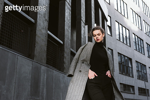 Portrait of a brunette fashion model in grey business suit near minimalistic building - gettyimageskorea
