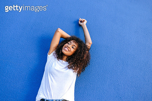 Portrait of smiling woman with blue background - gettyimageskorea