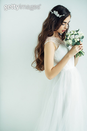 Studio shot of young beautiful bride on light background. Professional make-up and hairstyle. - gettyimageskorea