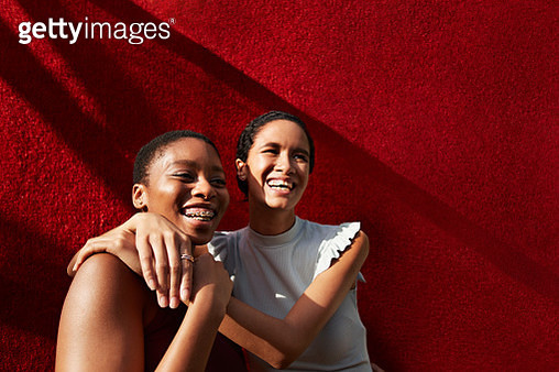 Smiling young woman standing with female friend - gettyimageskorea