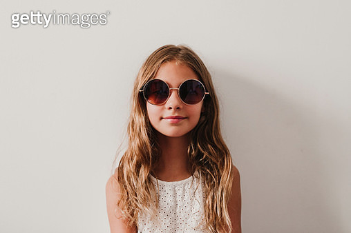 Portrait Of Smiling Cute Girl Wearing Sunglasses Against White Background - gettyimageskorea