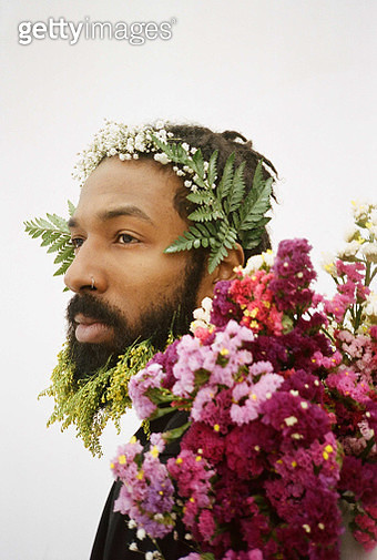 Portrait of young adult male adorned with flowers and plants - gettyimageskorea