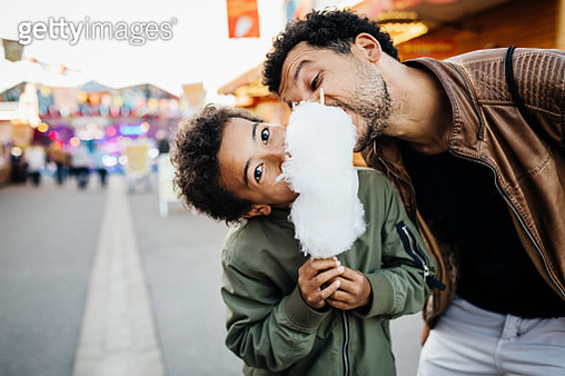 Playful Father And Son Sharing Candy Floss - gettyimageskorea
